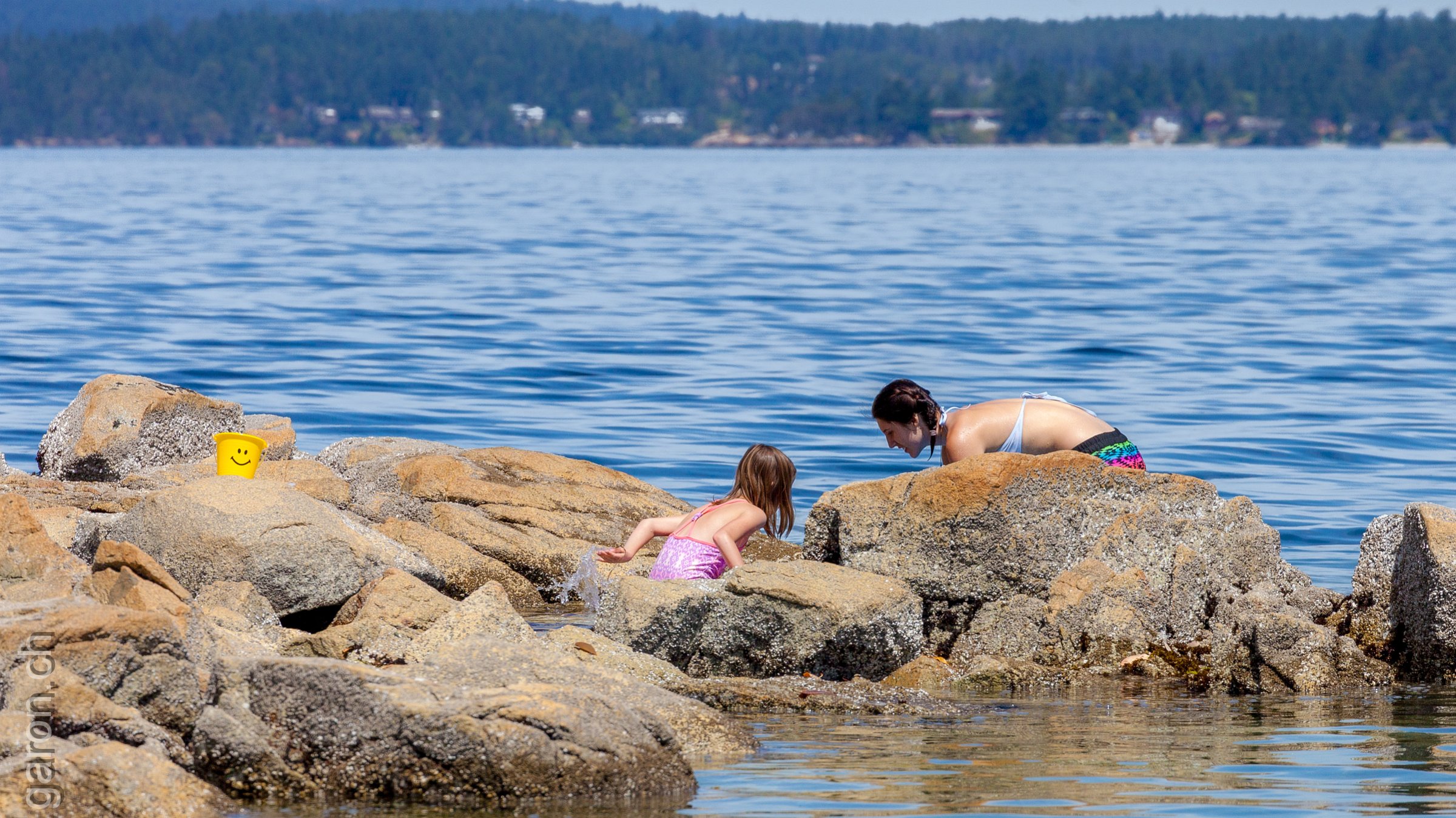 British Columbia, Victoria east coast Mother and daughter playing in coast water